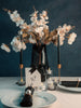 Decorative table setting for a couple with flowers, candles, and a card on a dark blue background
