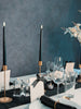Elegant black and white table setting with black candles, glasses, and decorative elements.
