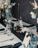 Elegant table setting with black candles, white flowers, and gold accents.