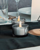 Two candle holders with lit candles on a table setting.