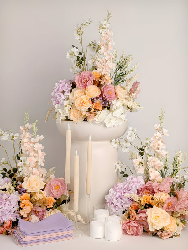 Floral arrangements and candles on a light gray background