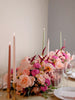Decorative floral arrangement with candles on a table setting.